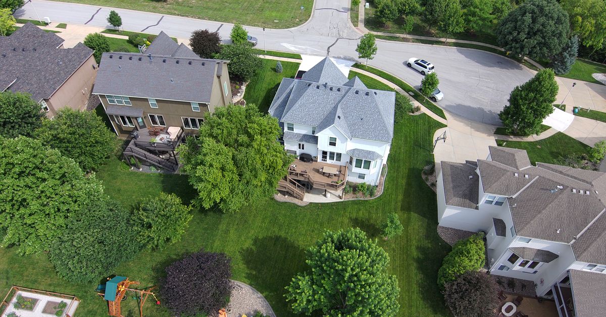 Bird's-eye view of residential area with green lawns and houses.