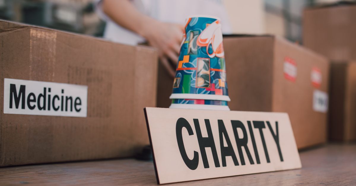 Close-up of charity boxes labeled for donation, featuring medicine and colorful paper cups.