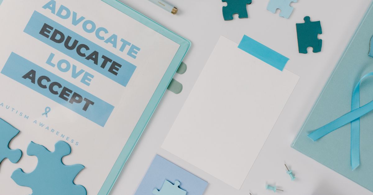 Flat lay of autism awareness materials including puzzle pieces and blue ribbons.