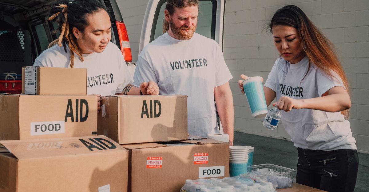 Volunteers sort aid and food boxes for a charity drive, promoting togetherness and social good.