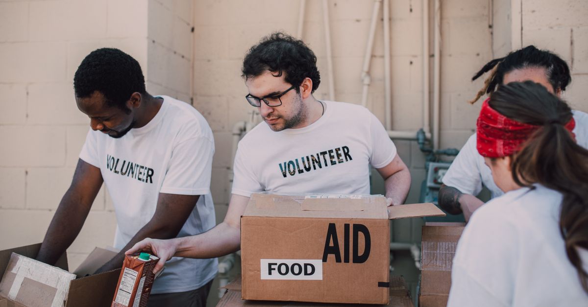 Group of volunteers packing food and aid boxes during a charity drive.