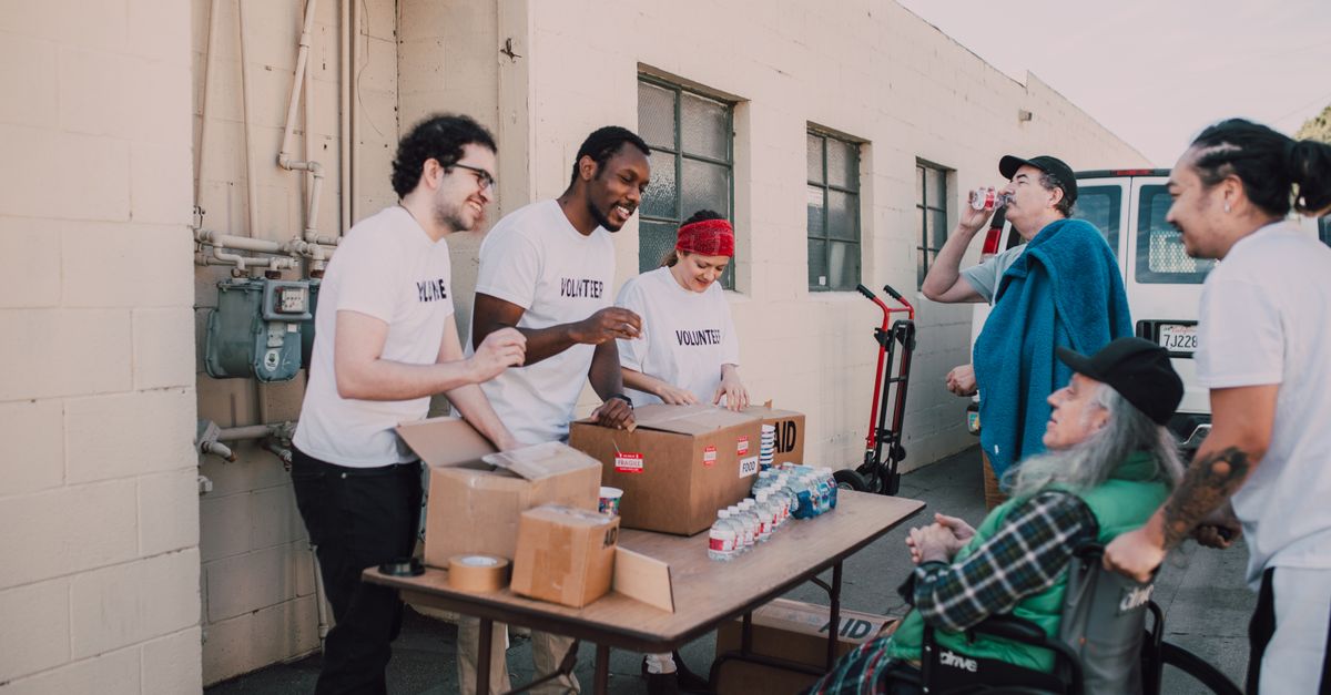 A group of diverse volunteers engaging in a community service activity outdoors, providing aid and support.