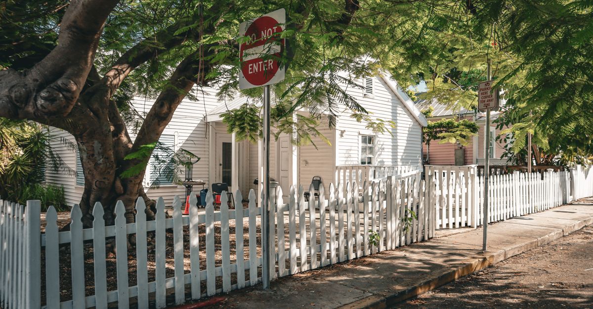 Beautiful house with a white picket fence and lush greenery in Key West, Florida.