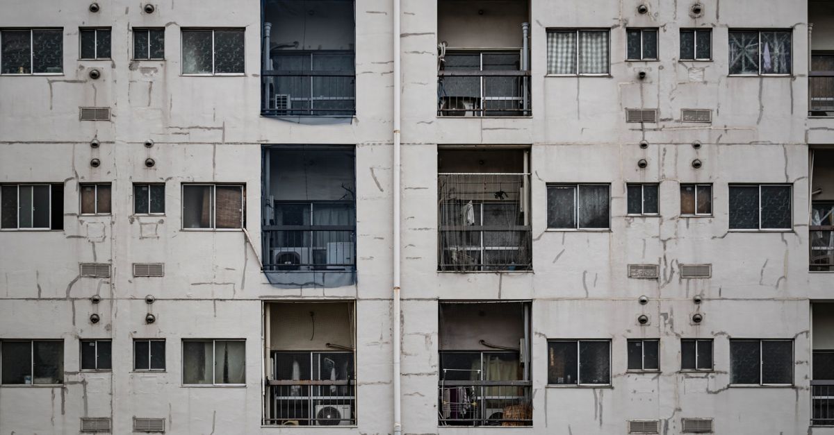 Close-up of a worn apartment building facade in Osaka, highlighting urban architecture.