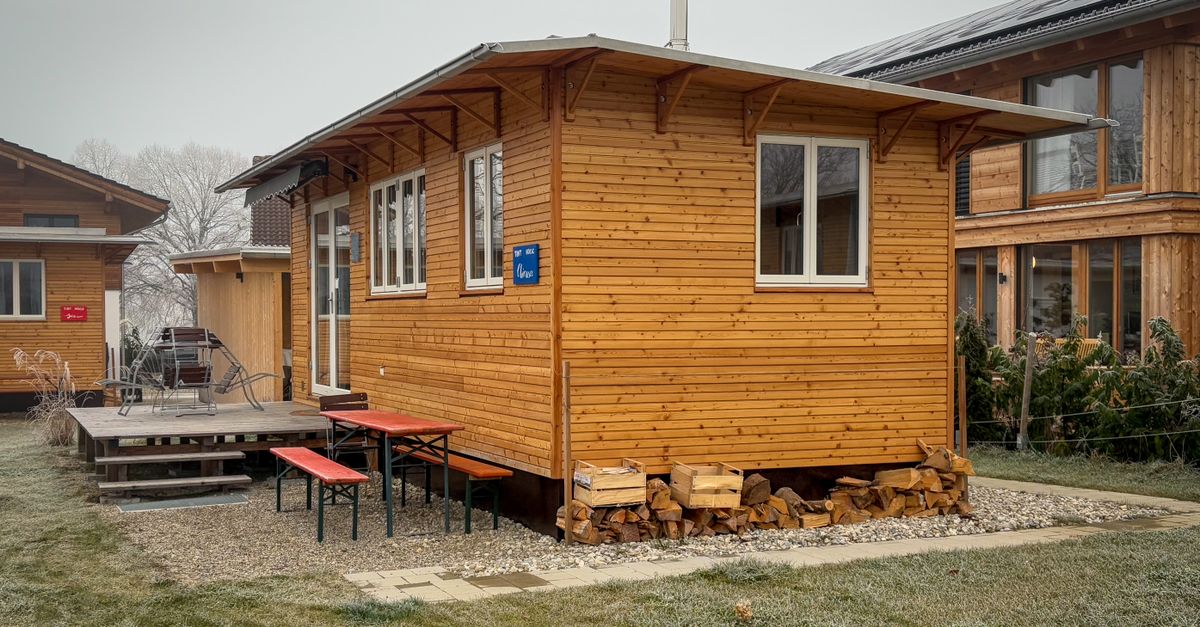 A charming wooden cabin with a small porch in a peaceful countryside location.