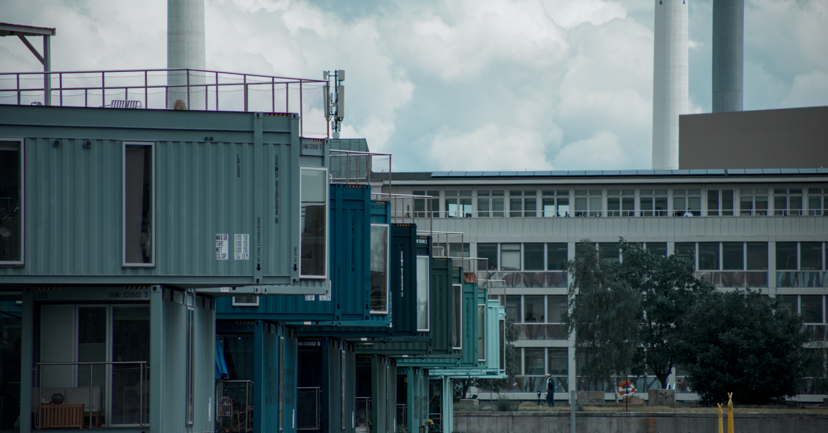 Colorful container homes on an urban waterfront showcasing modern architecture and industrial design.