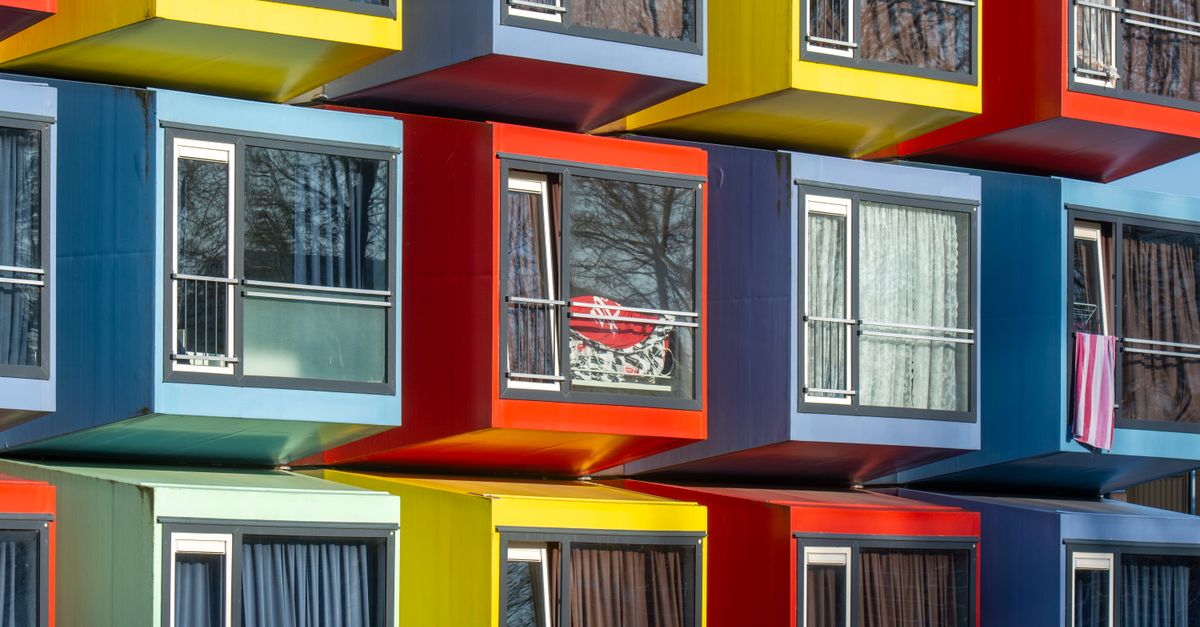 Vibrant stack of modular apartments creating a colorful urban facade in Almere, Netherlands.