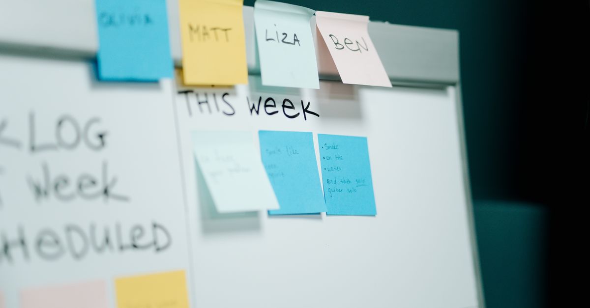 Close-up of a whiteboard with colorful sticky notes for task organization and planning.