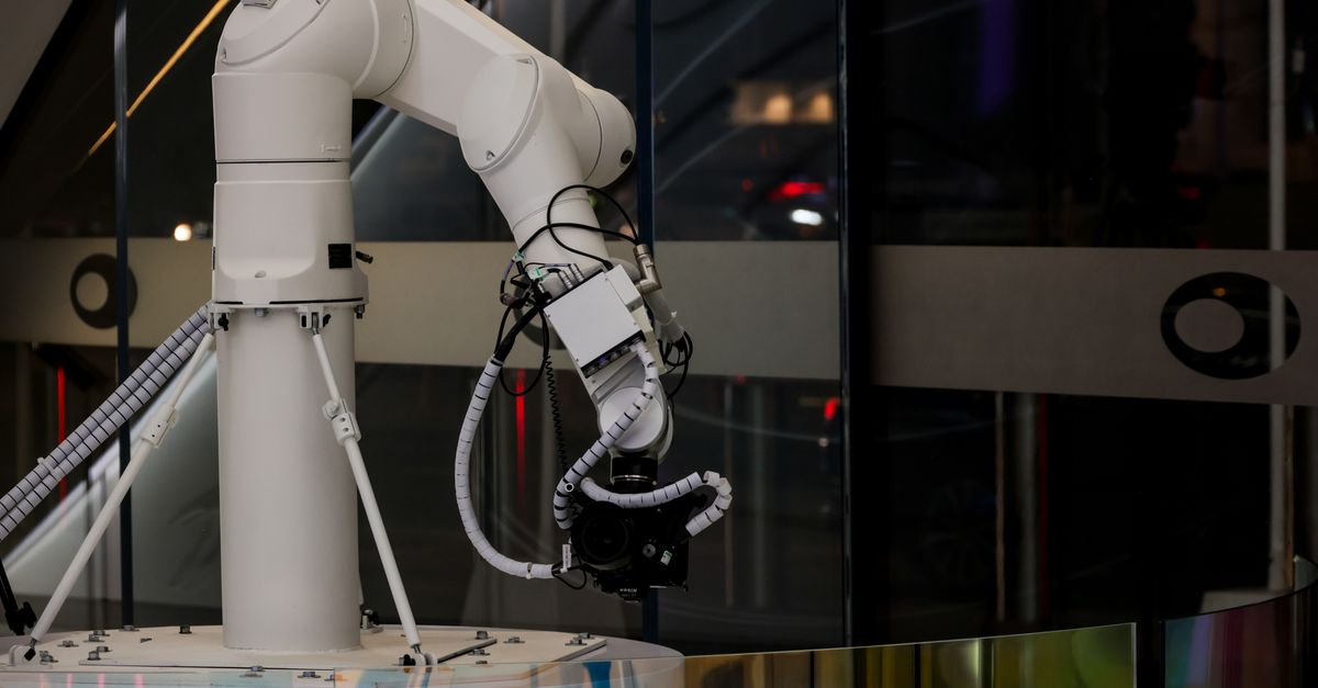 A white robotic arm operating indoors with a modern design and advanced technology.