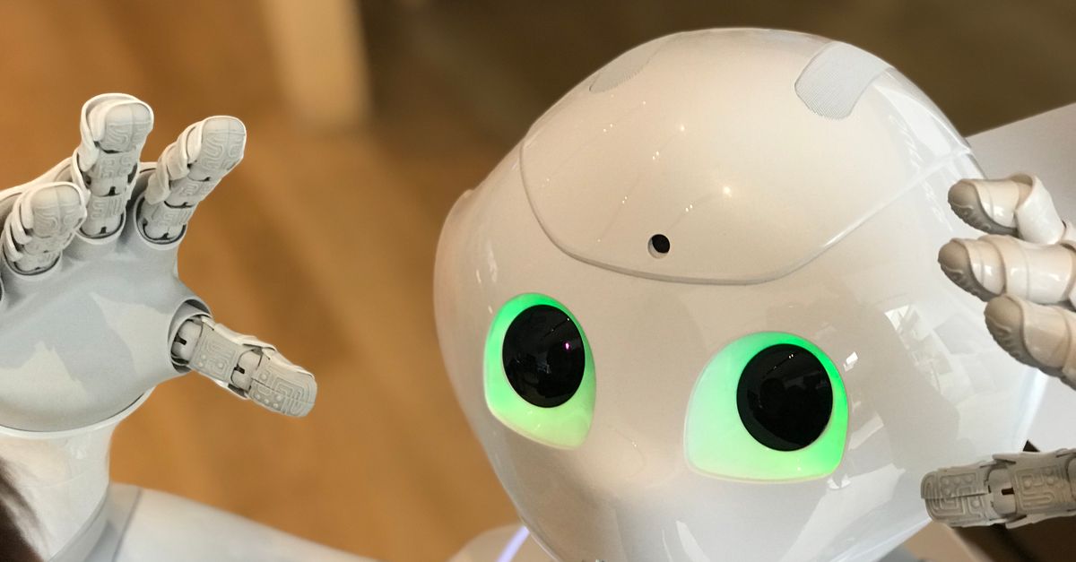 A futuristic humanoid robot with glowing green eyes in a modern setting.
