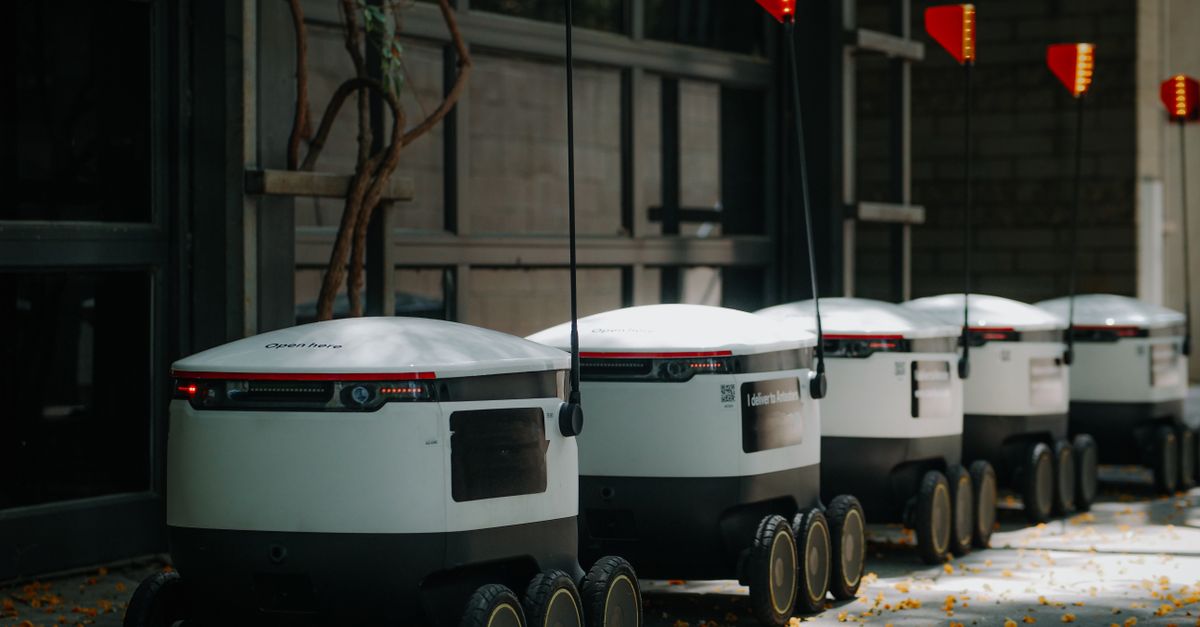 Futuristic delivery robots lined up in an urban environment, showcasing modern innovation.