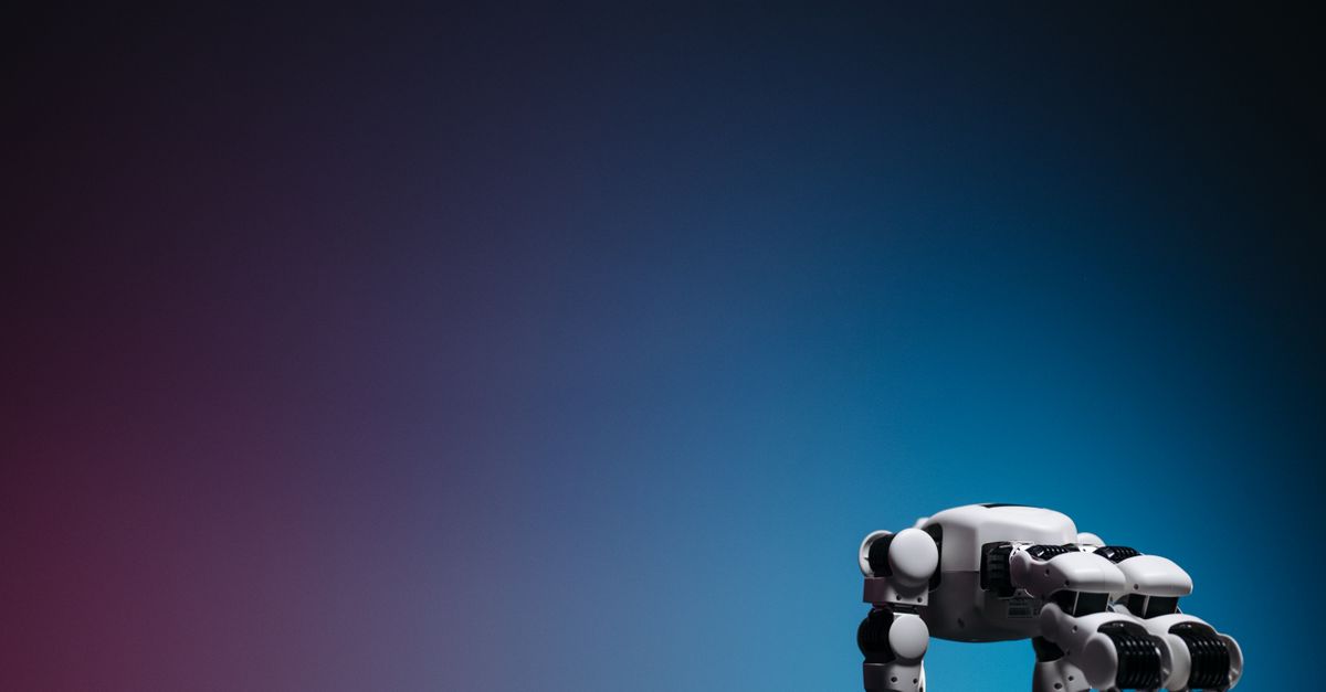 A close-up of a futuristic robot toy on a reflective surface against a gradient background.