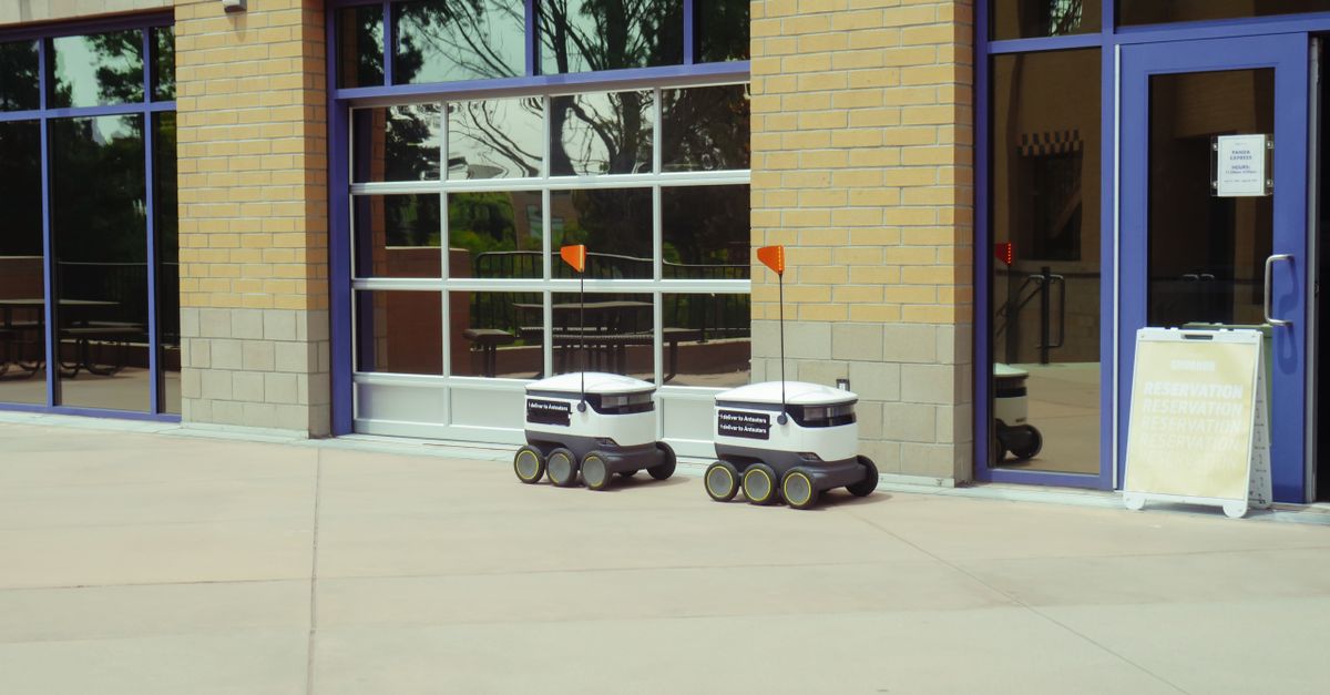 Two autonomous delivery robots navigate an outdoor space, showcasing modern technology and innovation.