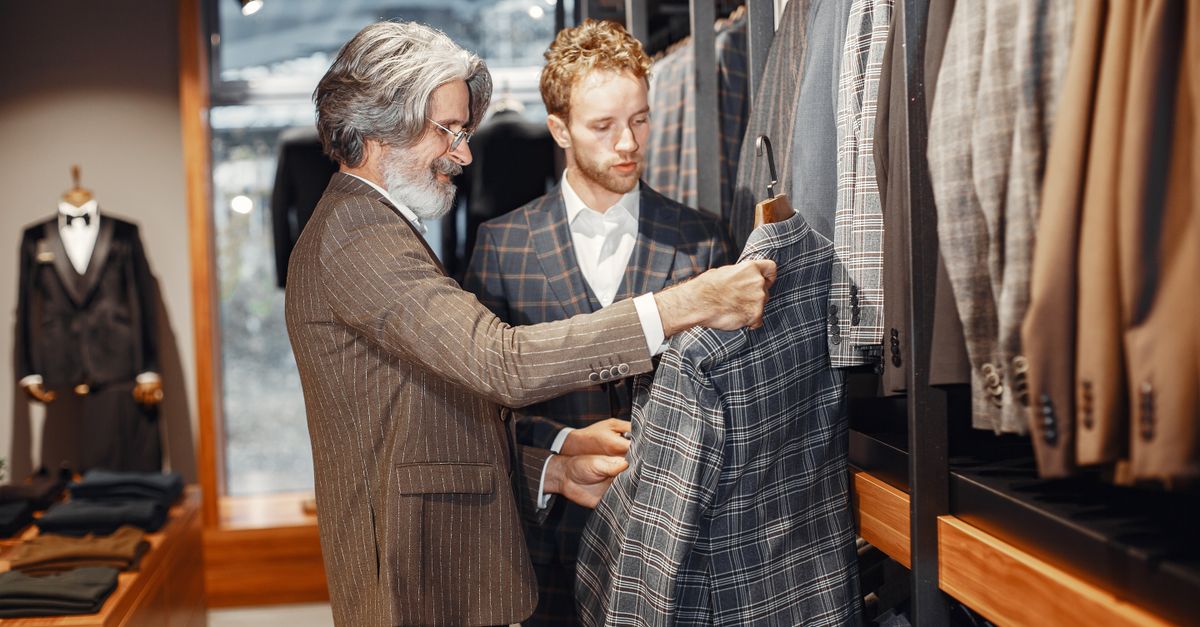Two men selecting stylish suits in a boutique store, focusing on elegance and style.