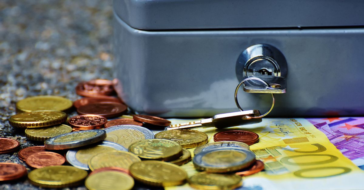 Close-up of a secure cash box with euro coins and banknotes, symbolizing wealth and financial security.