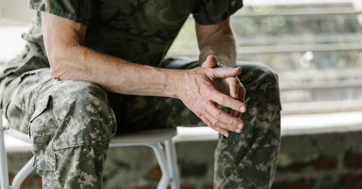 Close-up of a military veteran's hands in a therapy session, emphasizing mental health support.