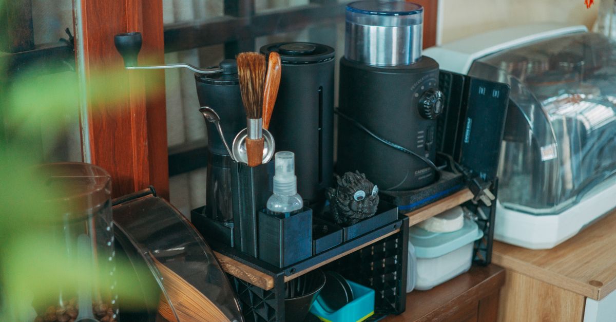 A tidy modern kitchen counter displaying various coffee-making equipment and kitchenware.
