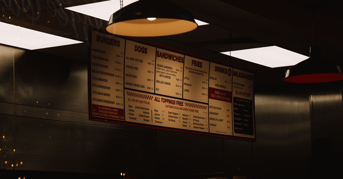 Dimly lit fast food restaurant interior with visible menu and ceiling lighting.