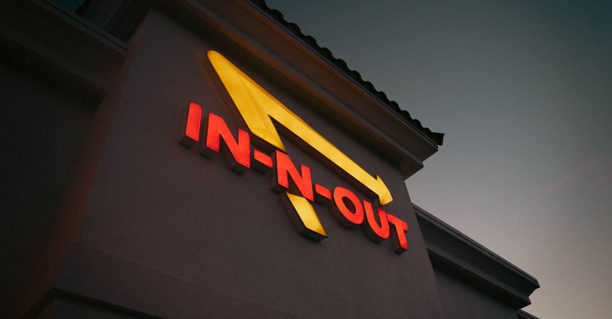 Dramatic shot of In-N-Out Burger sign with vibrant colors at dusk, capturing iconic branding.