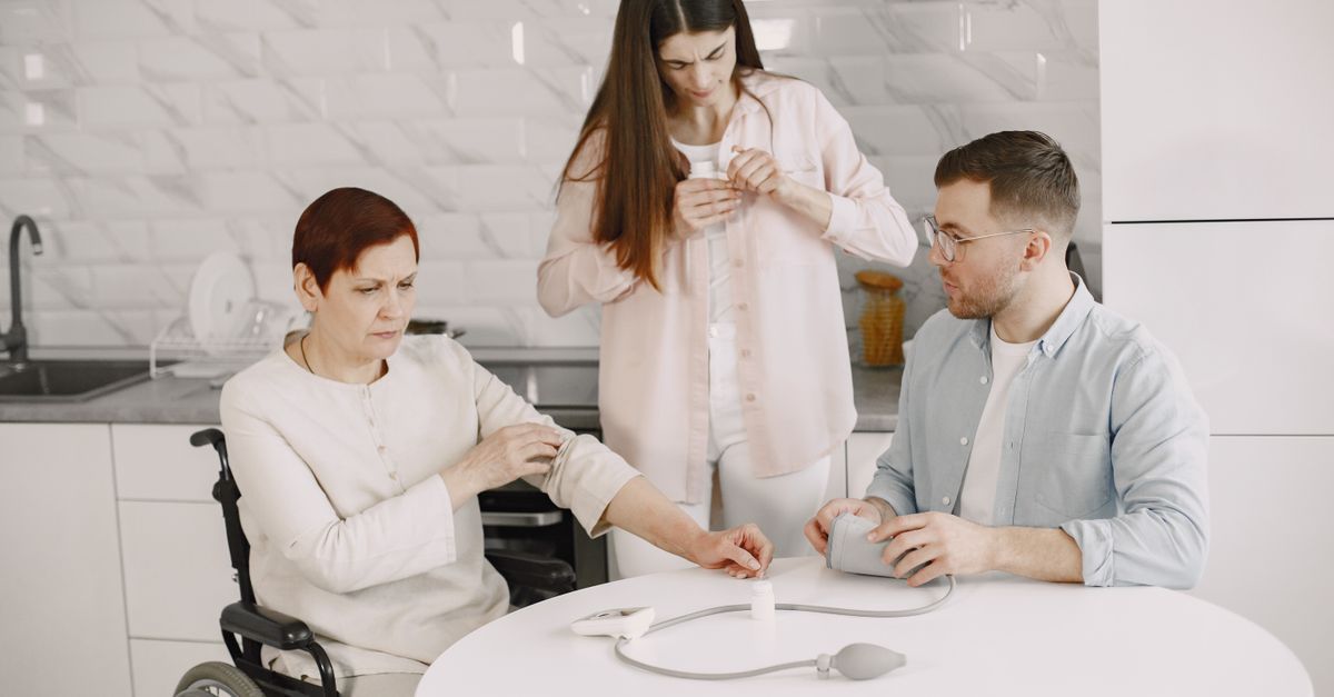 A family assists in measuring blood pressure at home, promoting healthcare awareness.