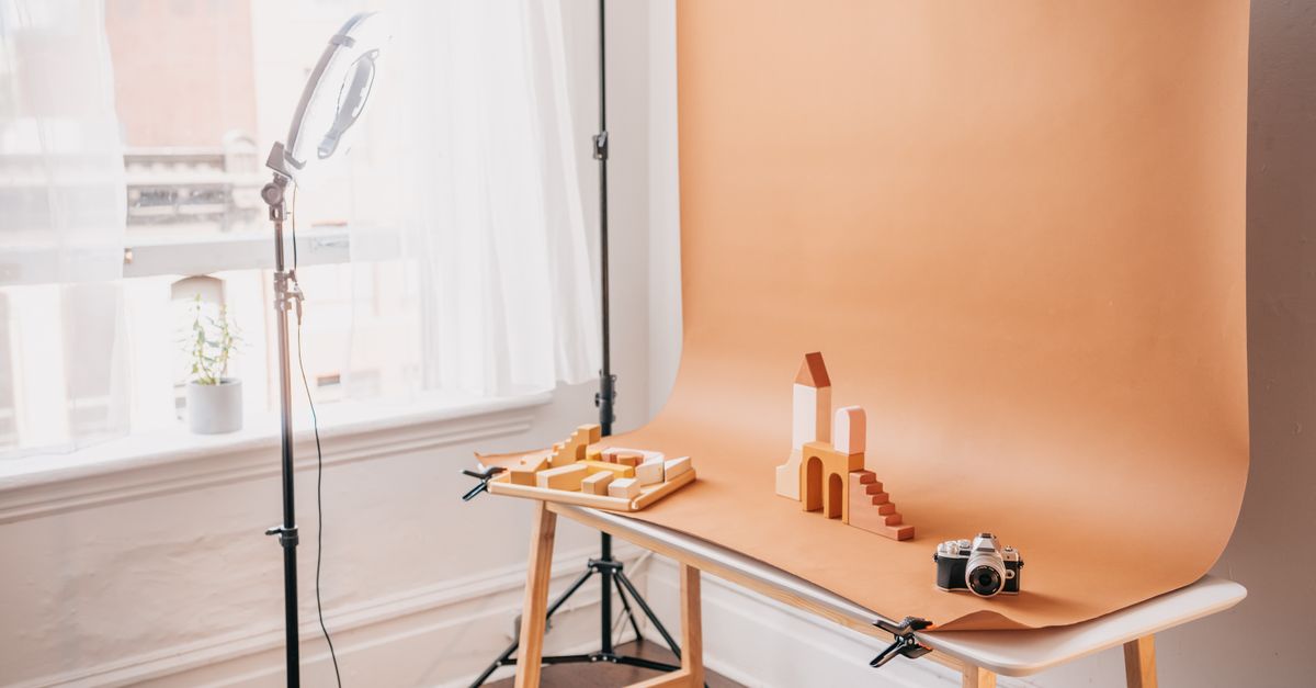 Minimalist studio scene featuring wooden blocks, backdrops, and vintage camera equipment.