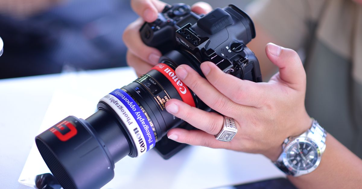 A photographer carefully adjusts a camera lens during a photoshoot, showcasing precision and attention to detail.