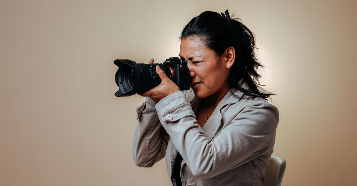 Female photographer with camera in a studio setting capturing the perfect shot.