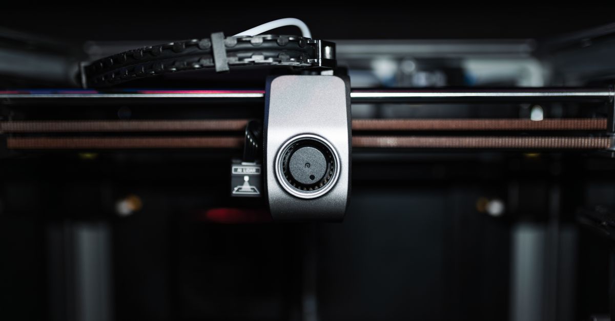 Macro shot of a 3D printer nozzle highlighting technology and precision.