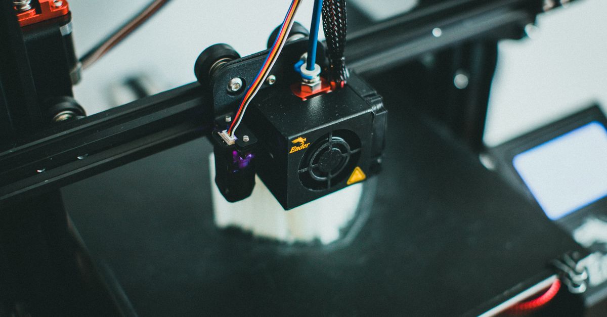 Detailed shot of a 3D printer creating an object, focusing on the cooling fan and print head.