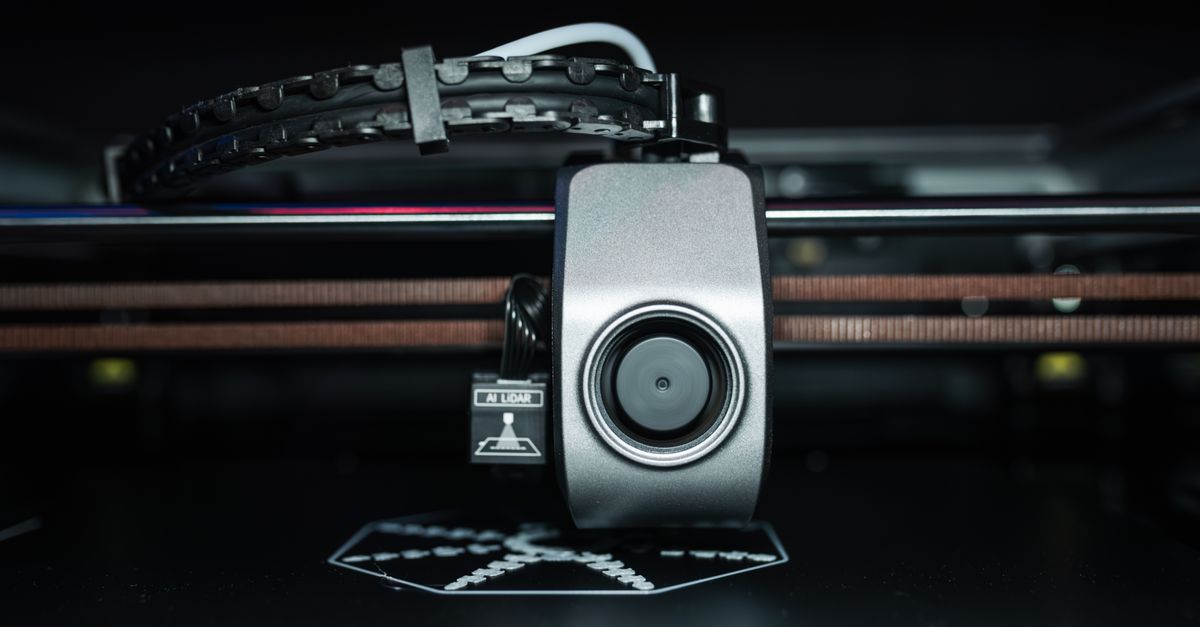 Detailed close-up of a 3D printer extrusion head in focus, showcasing modern technology.