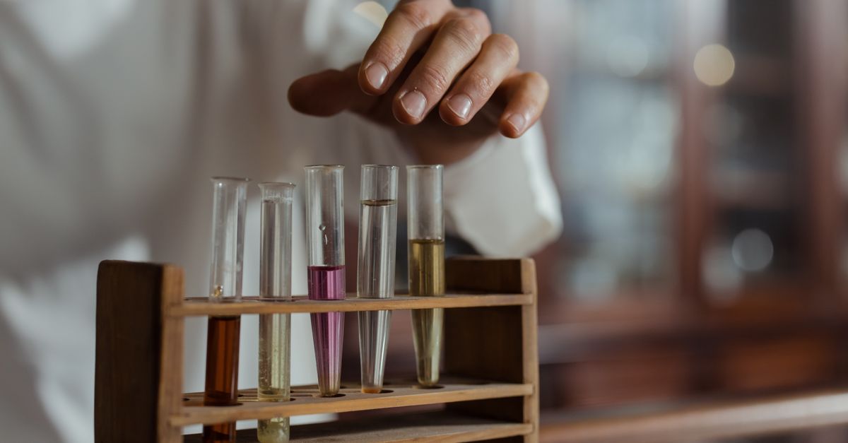 Close-up of a hand handling test tubes in a laboratory showcasing scientific research.