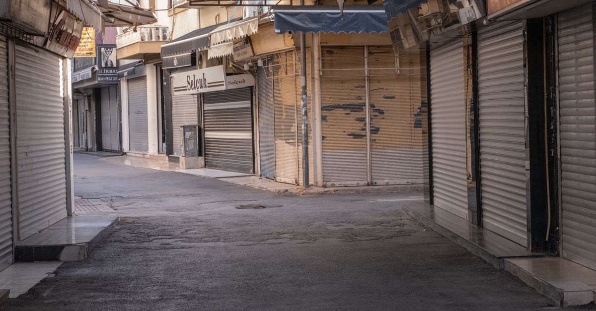 A deserted street in Izmir, Turkiye, lined with closed shops and shuttered storefronts.