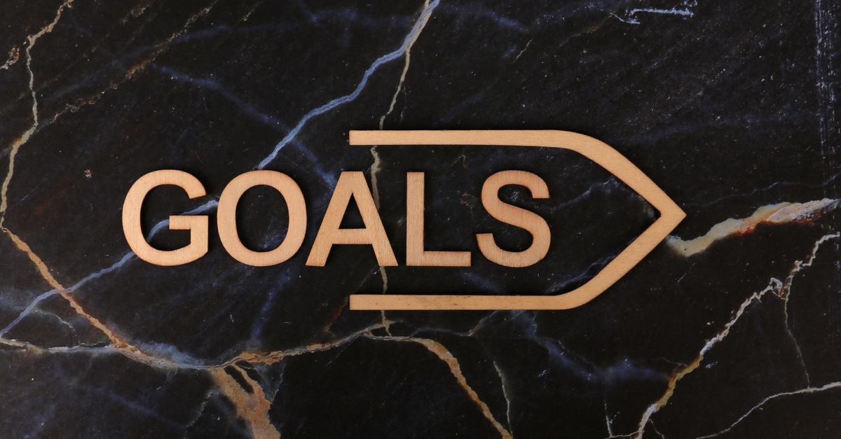 Inspiring image of a wooden 'GOALS' sign on a dark marble surface, symbolizing ambition.
