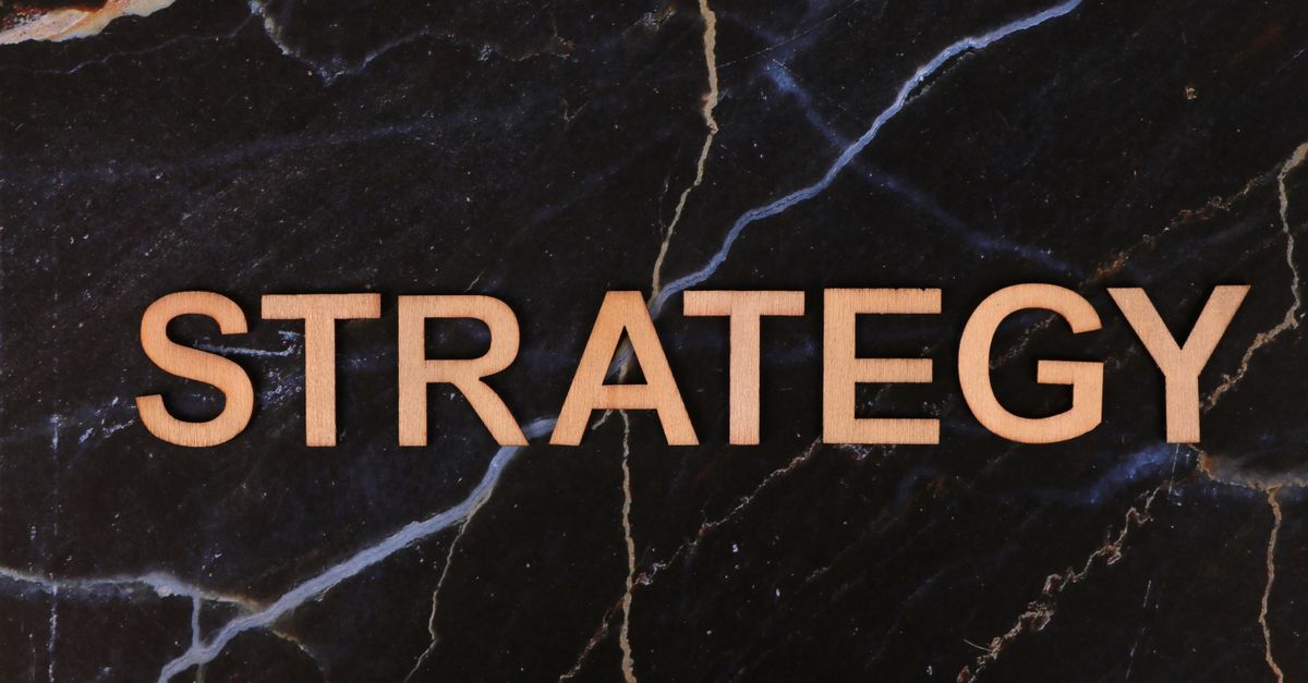 Strategic planning concept with 'Strategy' in wooden letters on dark marble.