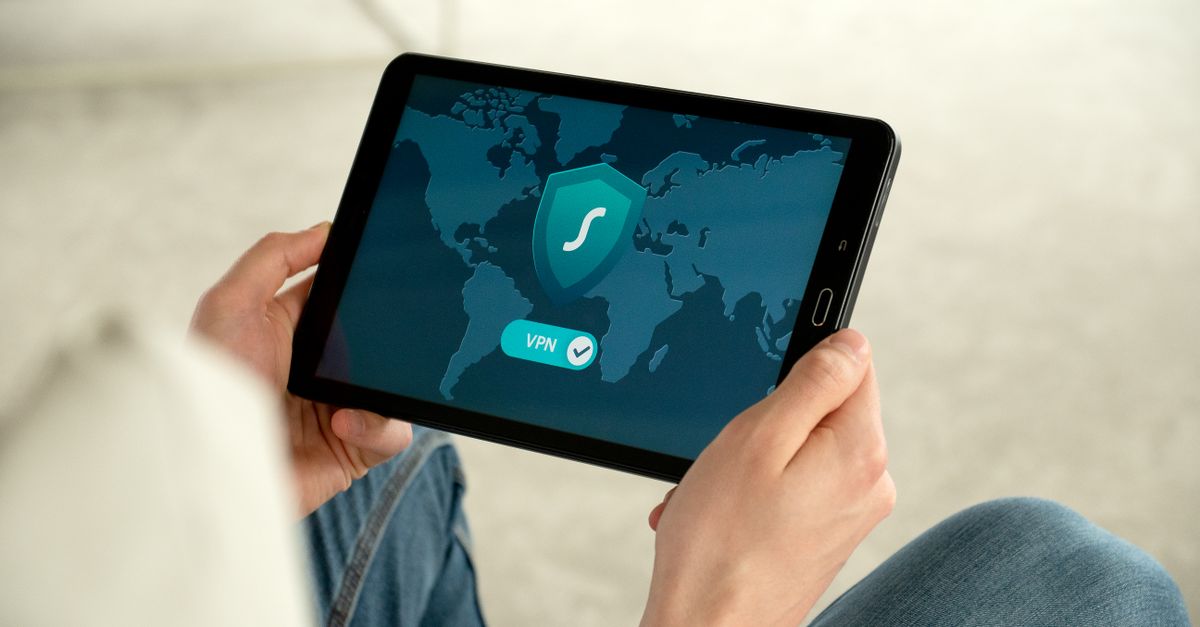 Person holding tablet with VPN connection screen for secure internet browsing.
