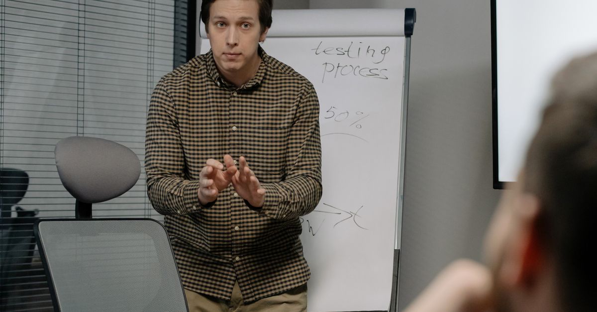 A man discusses testing processes during an office meeting with a focus on growth and strategy.