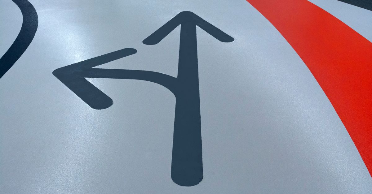 Close-up view of painted arrows on a parking garage floor indicating direction.