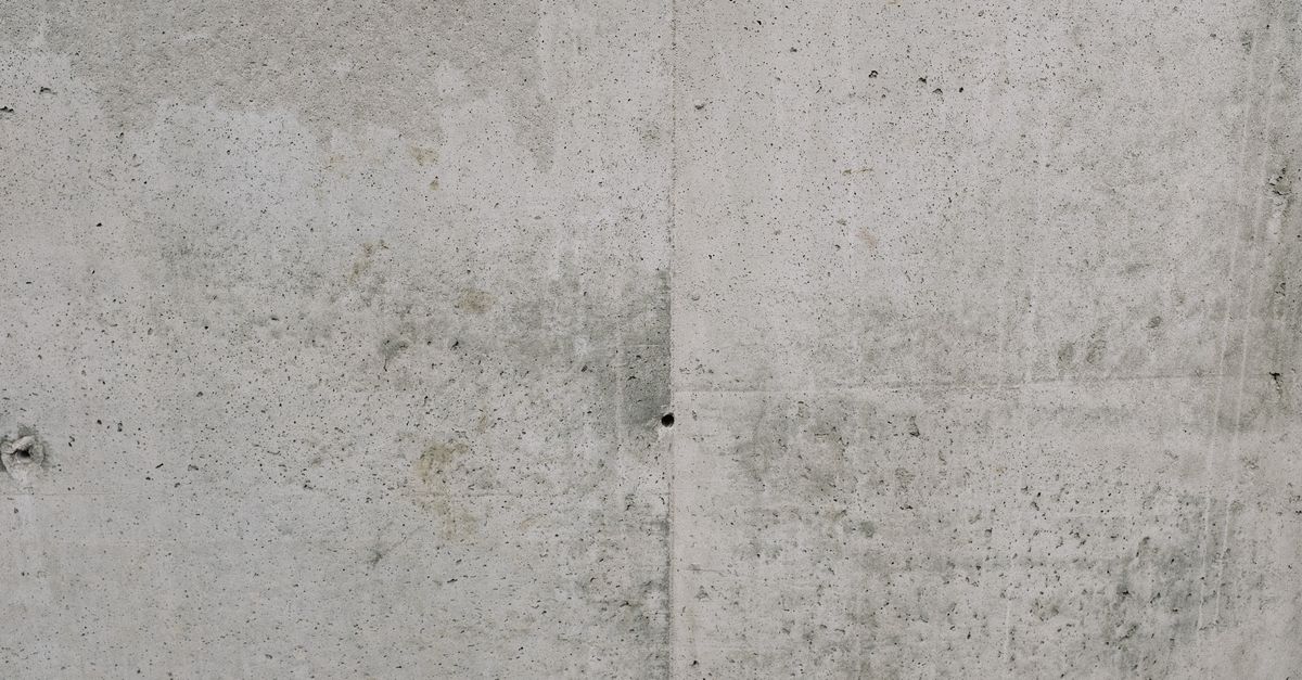 Close-up view of a rough textured concrete wall, ideal for backgrounds.