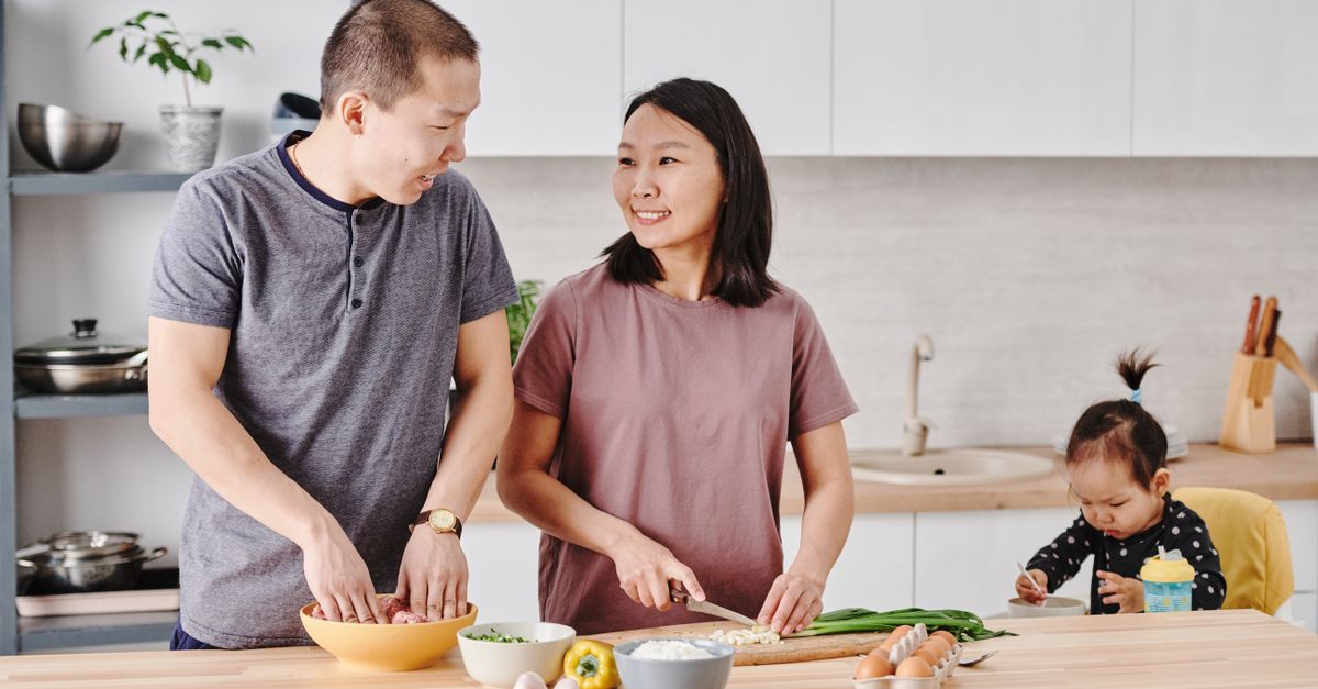 Asian family enjoying cooking together in a modern kitchen, fostering togetherness and love.