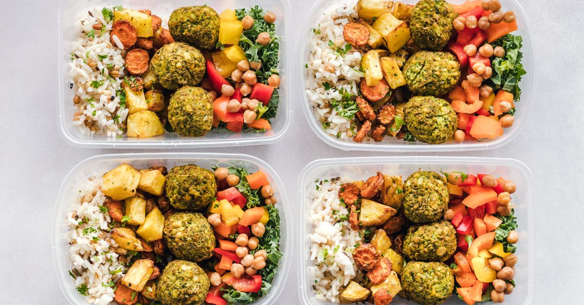 Colorful meal prep containers with falafel, chickpeas, rice, and vegetables for a healthy lifestyle.
