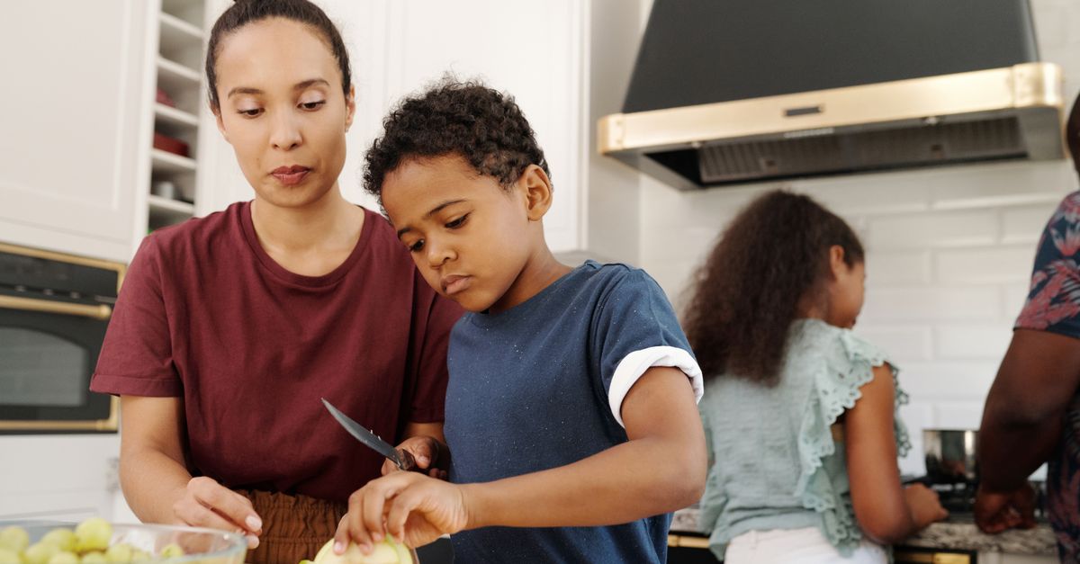 A family enjoys quality time preparing food together in a cozy kitchen setting.