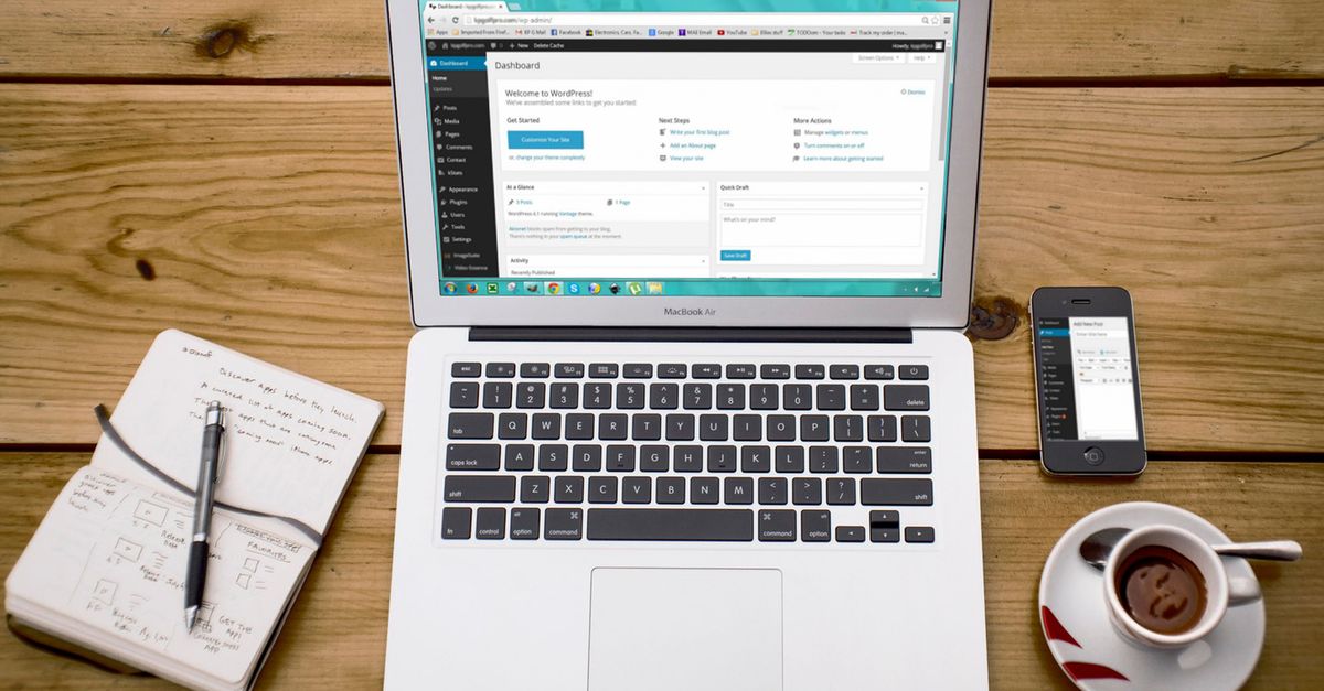 A cozy home office scene with a laptop, notebook, smartphone, and coffee, perfect for productivity.