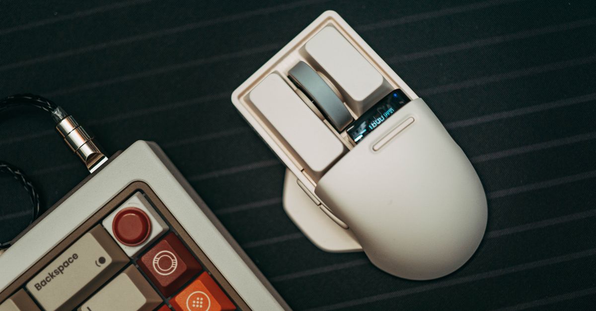 A sleek computer mouse and stylish keyboard on a dark surface. Modern tech essentials for efficient workspaces.