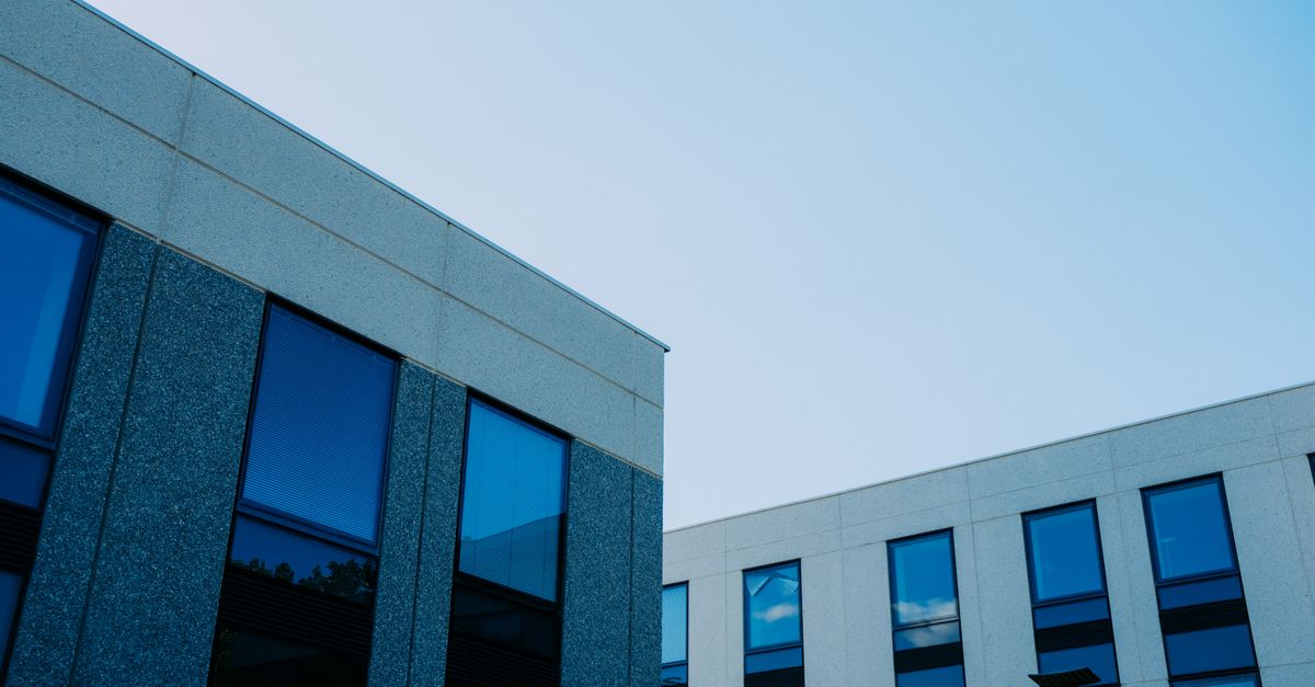 From below of contemporary office buildings with reflection in windows located in city