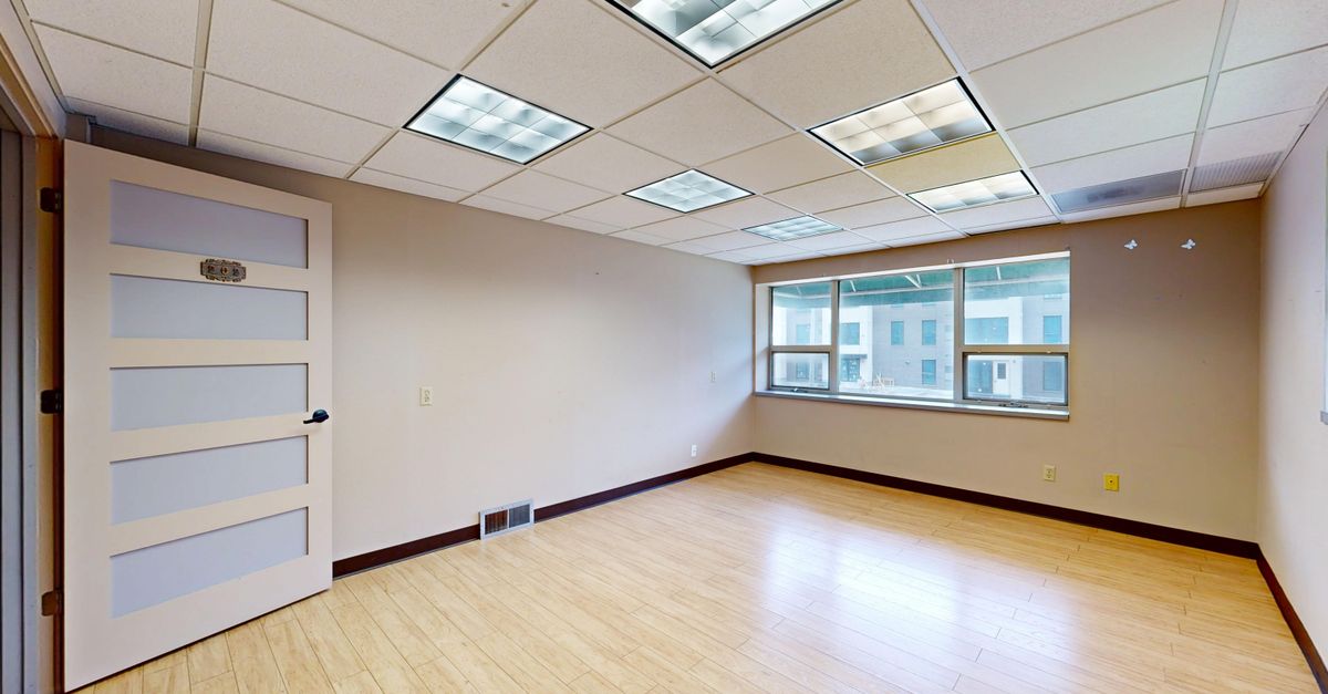 Vacant modern office space with large windows and natural light.