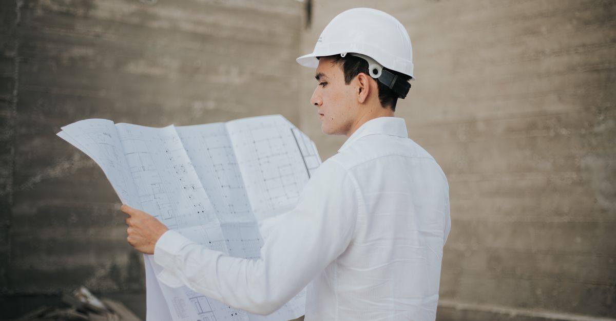 Architect examining blueprints at a construction site in Mexico.