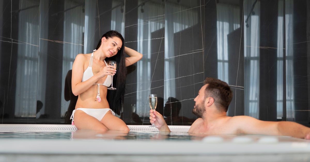 A young couple relaxing in a jacuzzi, enjoying their vacation with champagne.