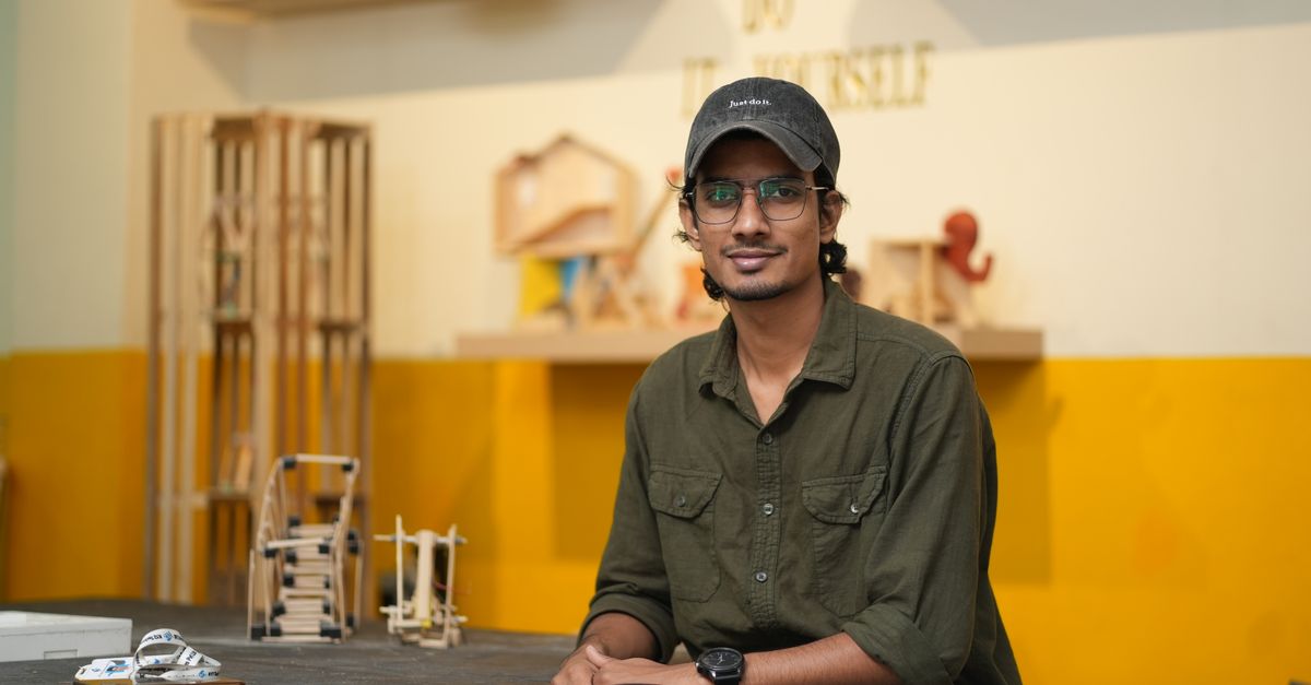 A young engineer in a DIY workshop surrounded by projects and tools, showcasing creativity and craftsmanship.