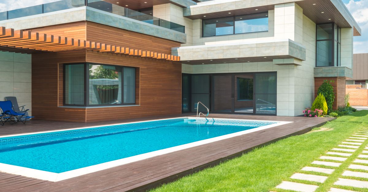 A stunning modern house with a spacious pool and green garden, ideal for relaxation.