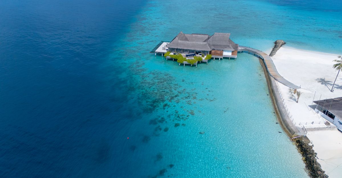 A stunning aerial view of a tropical resort on the turquoise waters of the Maldives.